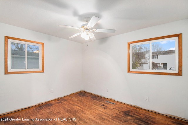 empty room featuring wood-type flooring, ceiling fan, and plenty of natural light