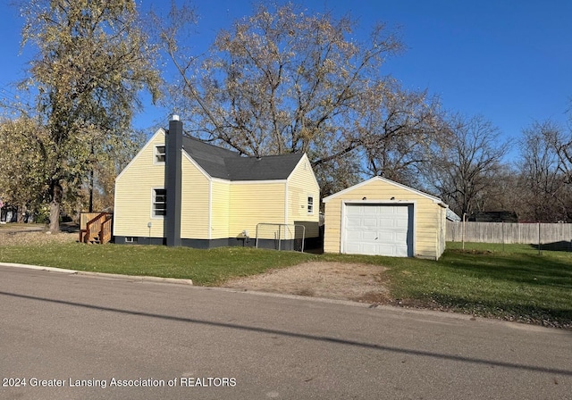 view of home's exterior featuring an outbuilding, a garage, a deck, and a lawn