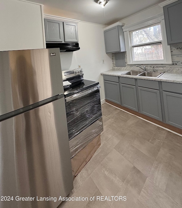 kitchen featuring gray cabinets, sink, and stainless steel refrigerator