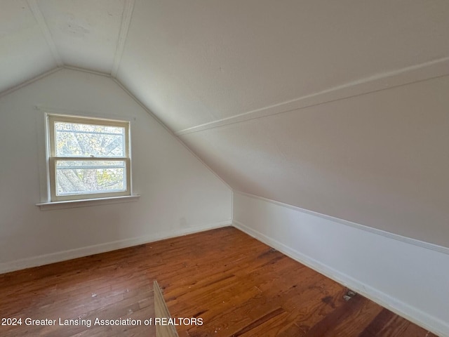 additional living space featuring hardwood / wood-style flooring and vaulted ceiling