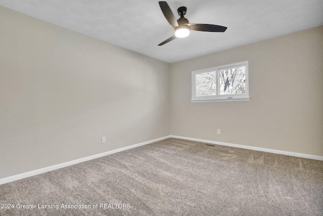 carpeted spare room featuring ceiling fan