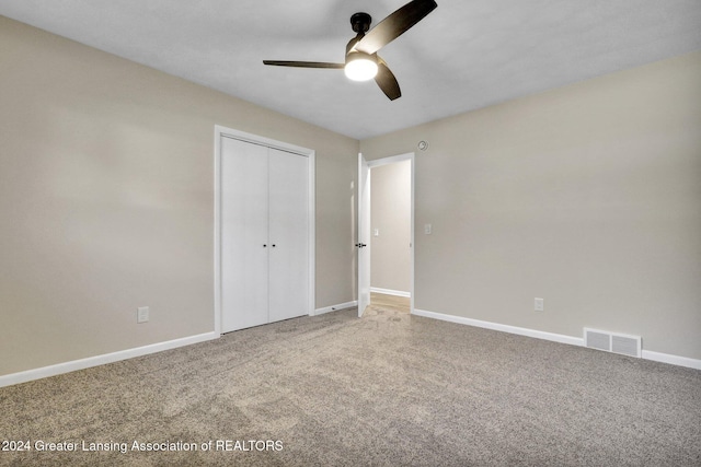 unfurnished bedroom with ceiling fan, a closet, and carpet