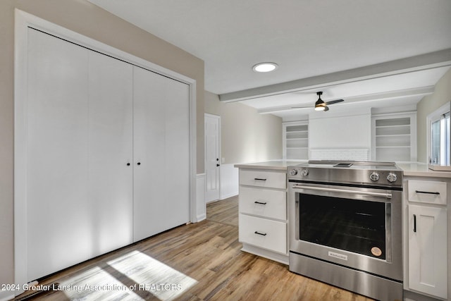 kitchen featuring ceiling fan, light hardwood / wood-style flooring, beamed ceiling, white cabinets, and stainless steel electric range