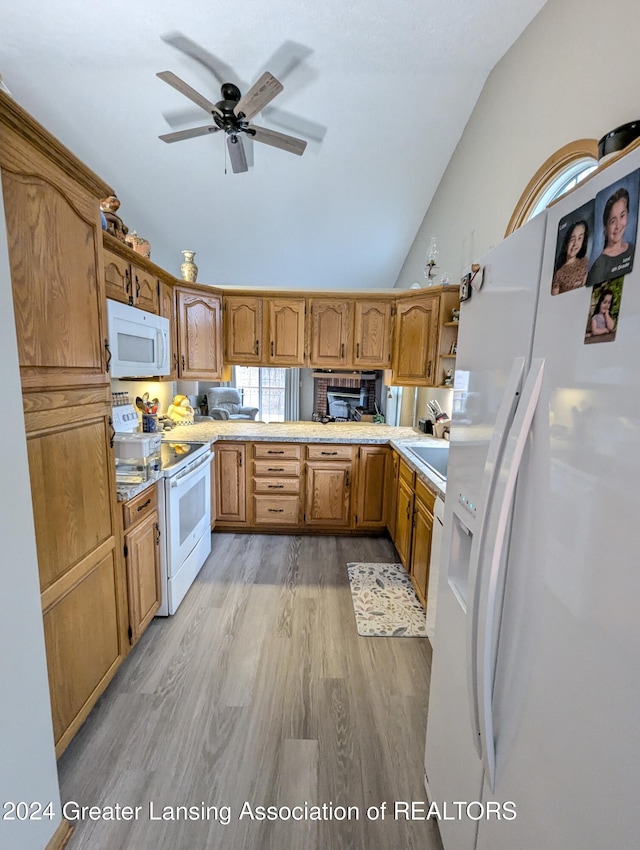 kitchen with lofted ceiling, light hardwood / wood-style flooring, ceiling fan, and white appliances