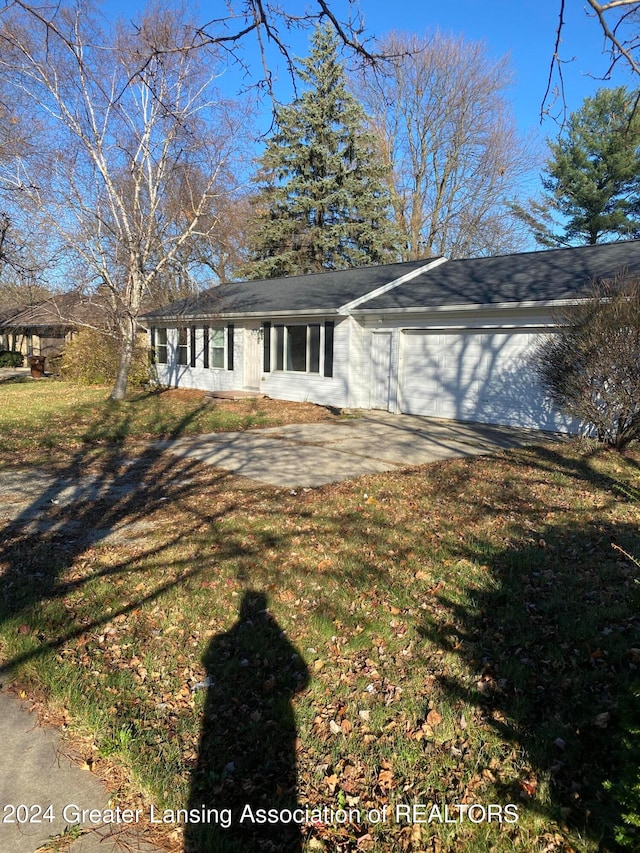 view of front of house featuring a garage, concrete driveway, and a front yard