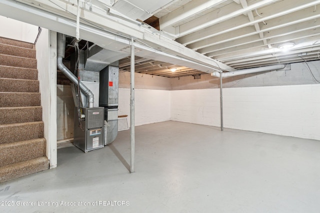 unfinished basement featuring heating unit and stairway