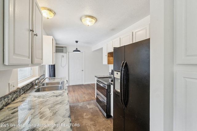 kitchen featuring range with two ovens, black fridge, a sink, and white cabinets