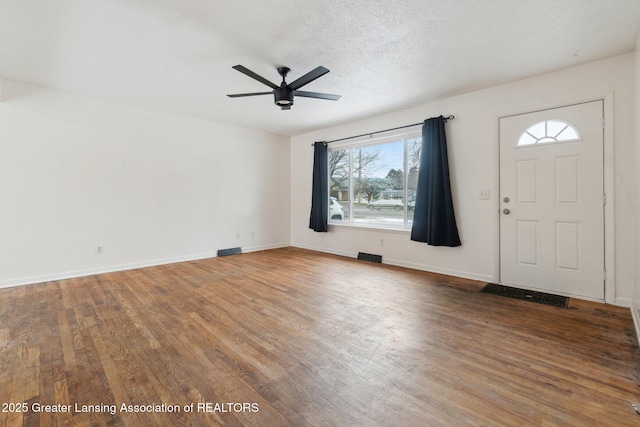 entryway featuring a ceiling fan, a textured ceiling, baseboards, and wood finished floors