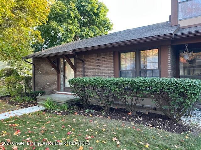 view of exterior entry with a yard