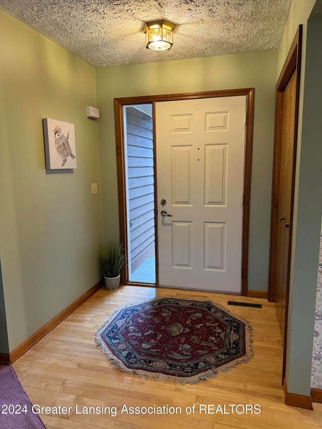 entryway featuring light hardwood / wood-style floors and a textured ceiling