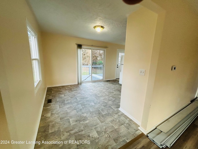 unfurnished room with a textured ceiling