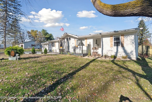 rear view of house featuring a yard