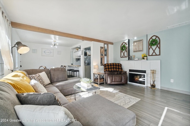 living room featuring a notable chandelier, wood-type flooring, and beam ceiling