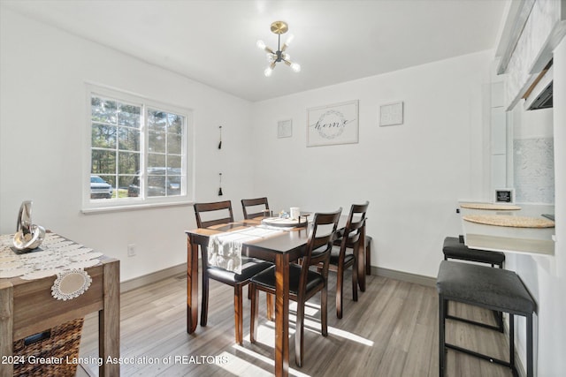 dining area featuring an inviting chandelier and light hardwood / wood-style flooring