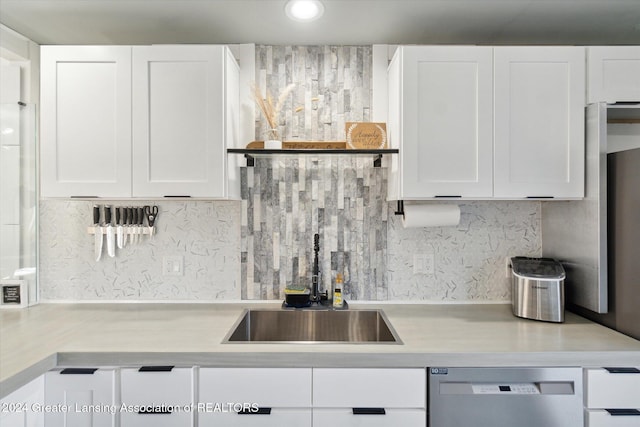 kitchen featuring white cabinets, stainless steel dishwasher, and sink