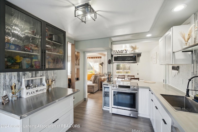 kitchen with white cabinetry, decorative backsplash, dark hardwood / wood-style flooring, and electric range