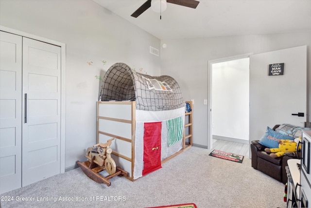 carpeted bedroom featuring lofted ceiling, ceiling fan, and a closet