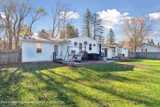 rear view of house with a pergola, a lawn, and a deck