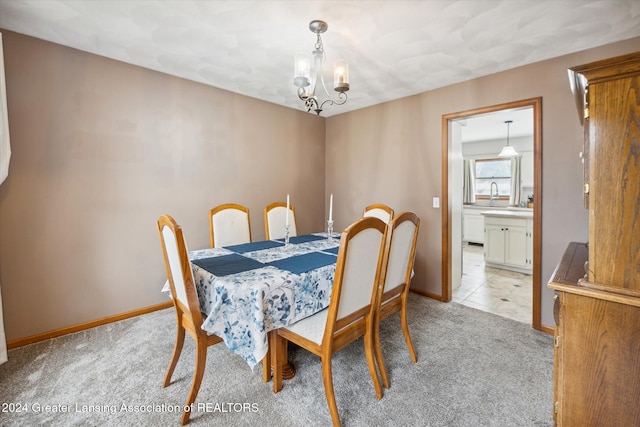 carpeted dining area with a chandelier