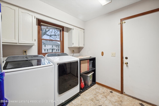 washroom featuring washing machine and dryer and cabinets