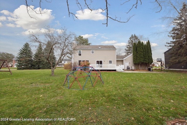 rear view of property with a lawn and a deck