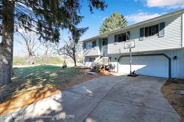 bi-level home featuring a garage and a front lawn