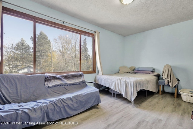 bedroom with a textured ceiling and light hardwood / wood-style floors