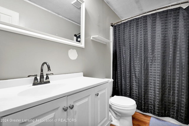 bathroom featuring a shower with shower curtain, a textured ceiling, wood-type flooring, vanity, and toilet