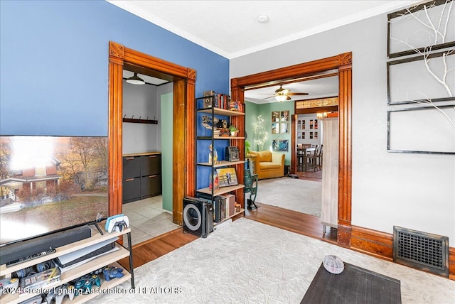 interior space with light hardwood / wood-style floors, ceiling fan, and crown molding