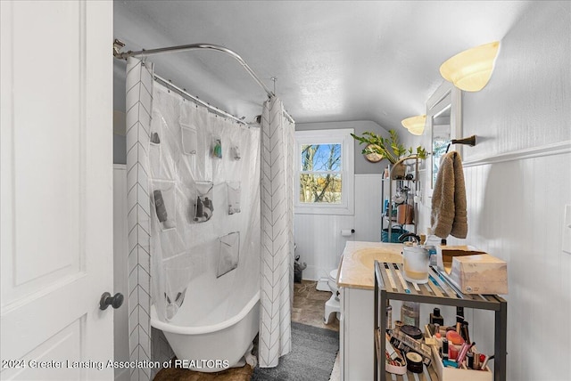 bathroom featuring lofted ceiling, a textured ceiling, vanity, and plus walk in shower