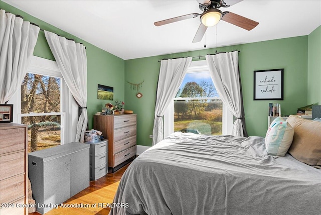 bedroom with light hardwood / wood-style flooring, multiple windows, and ceiling fan