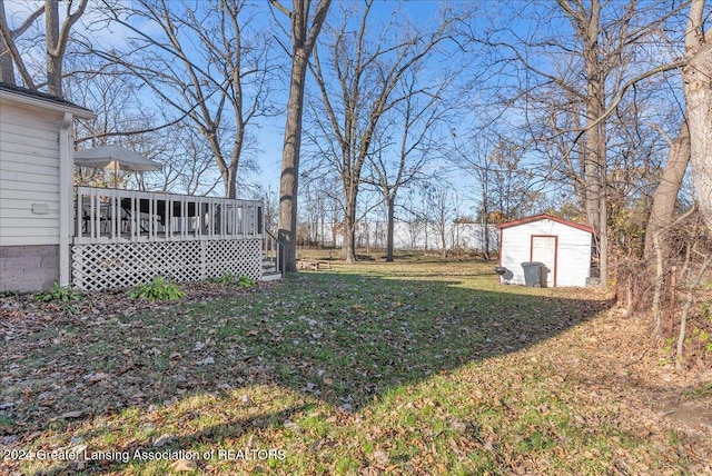 view of yard featuring a storage unit and a wooden deck