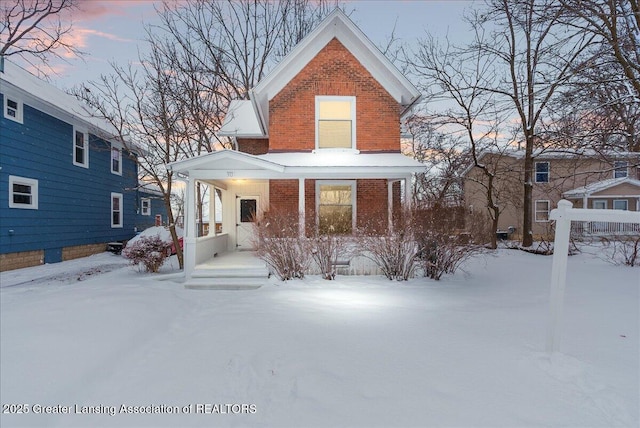 snow covered property with covered porch