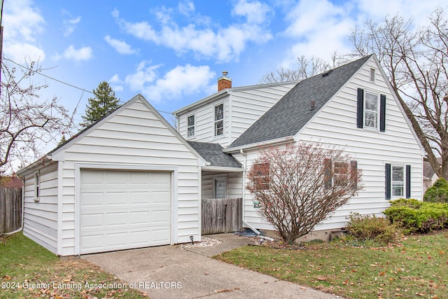 view of front of home with a garage, a front lawn, and an outdoor structure