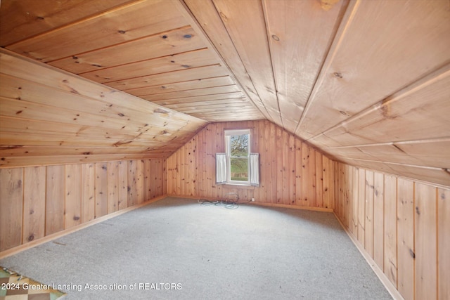 additional living space with wooden walls, carpet, wood ceiling, and lofted ceiling