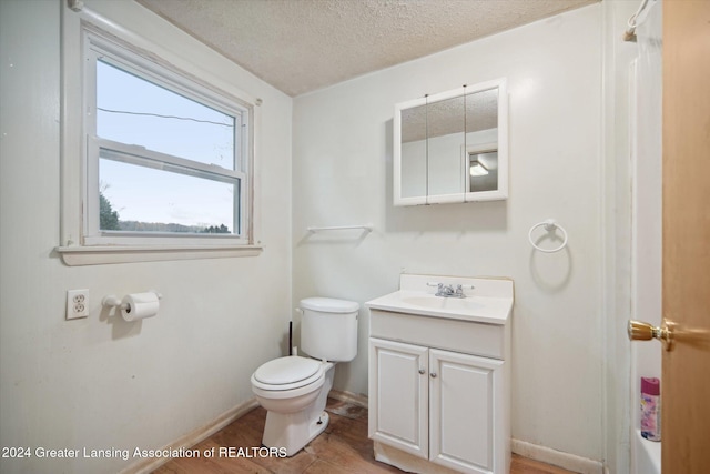 bathroom featuring vanity, a textured ceiling, and toilet