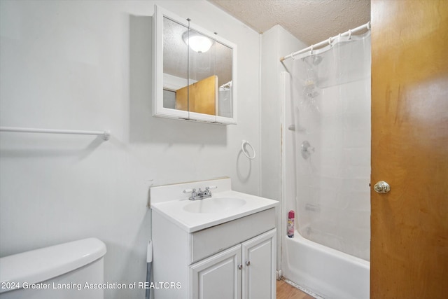 full bathroom featuring vanity, hardwood / wood-style flooring, toilet, a textured ceiling, and shower / tub combo