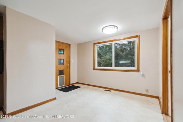 interior space featuring light floors, visible vents, and baseboards