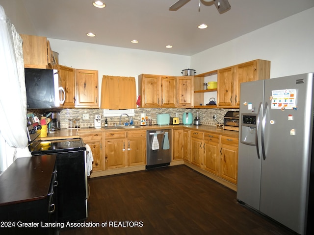 kitchen with sink, appliances with stainless steel finishes, dark hardwood / wood-style flooring, and tasteful backsplash