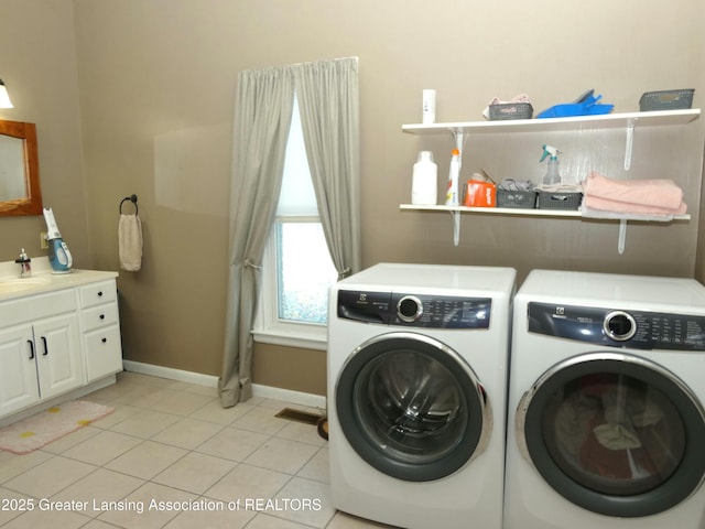 laundry room featuring light tile patterned flooring, independent washer and dryer, and sink