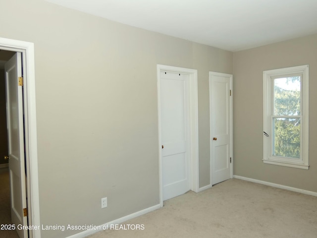 unfurnished bedroom featuring light carpet