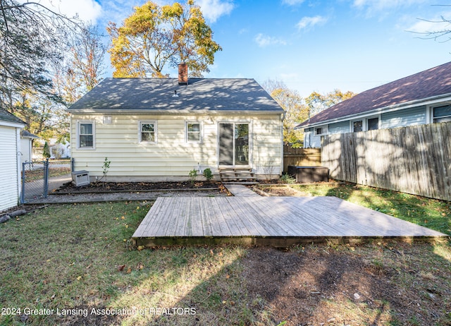 back of property with a yard and a wooden deck