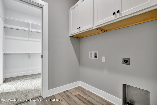 laundry room featuring electric dryer hookup, hookup for a washing machine, cabinets, and light wood-type flooring