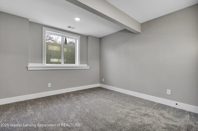 carpeted empty room featuring beamed ceiling