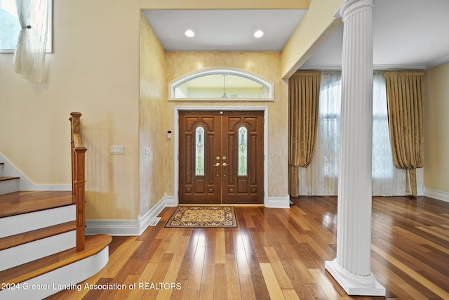 foyer featuring wood-type flooring and ornate columns