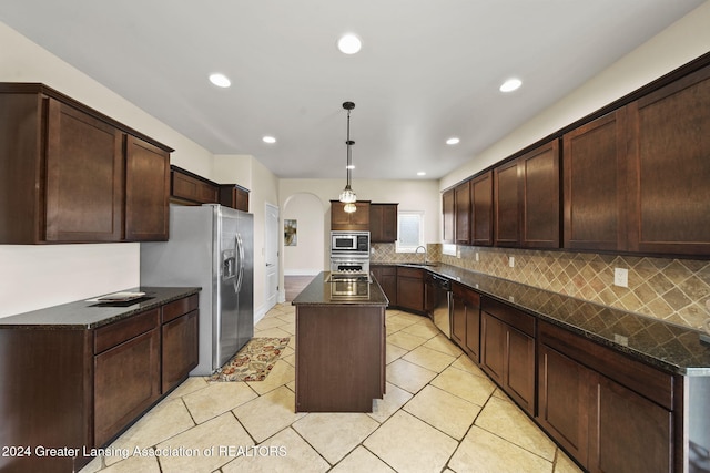 kitchen featuring pendant lighting, sink, appliances with stainless steel finishes, a kitchen island, and dark brown cabinetry