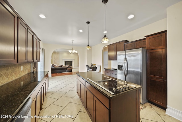 kitchen featuring decorative backsplash, appliances with stainless steel finishes, light tile patterned floors, a center island, and hanging light fixtures