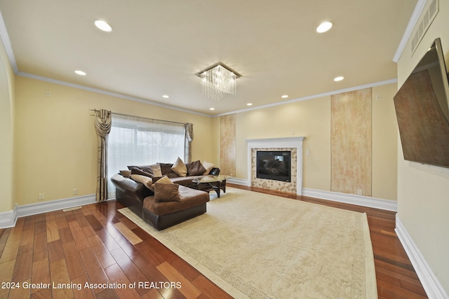 living room with dark hardwood / wood-style flooring, crown molding, and an inviting chandelier