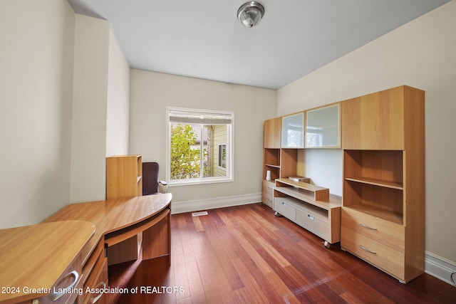 unfurnished office with built in desk and dark wood-type flooring