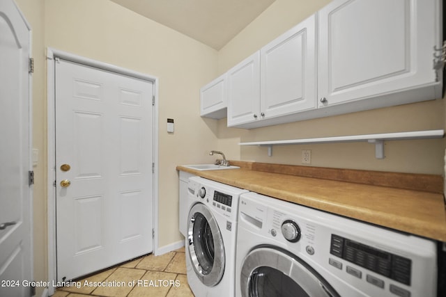 laundry room with sink, washing machine and dryer, cabinets, and light tile patterned flooring